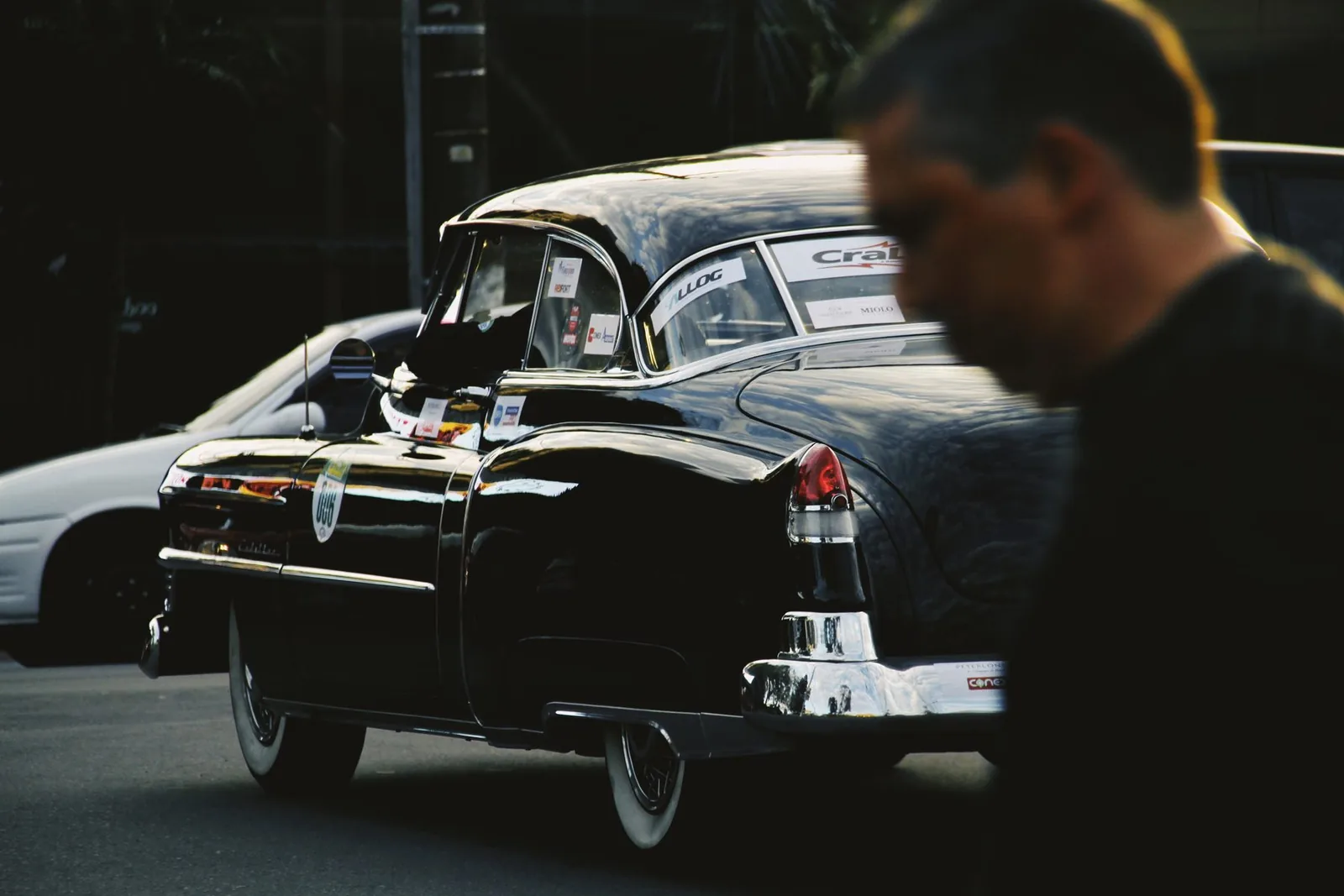 Cadillac preto de rabo de peixe visto de trás, no fim da tarde