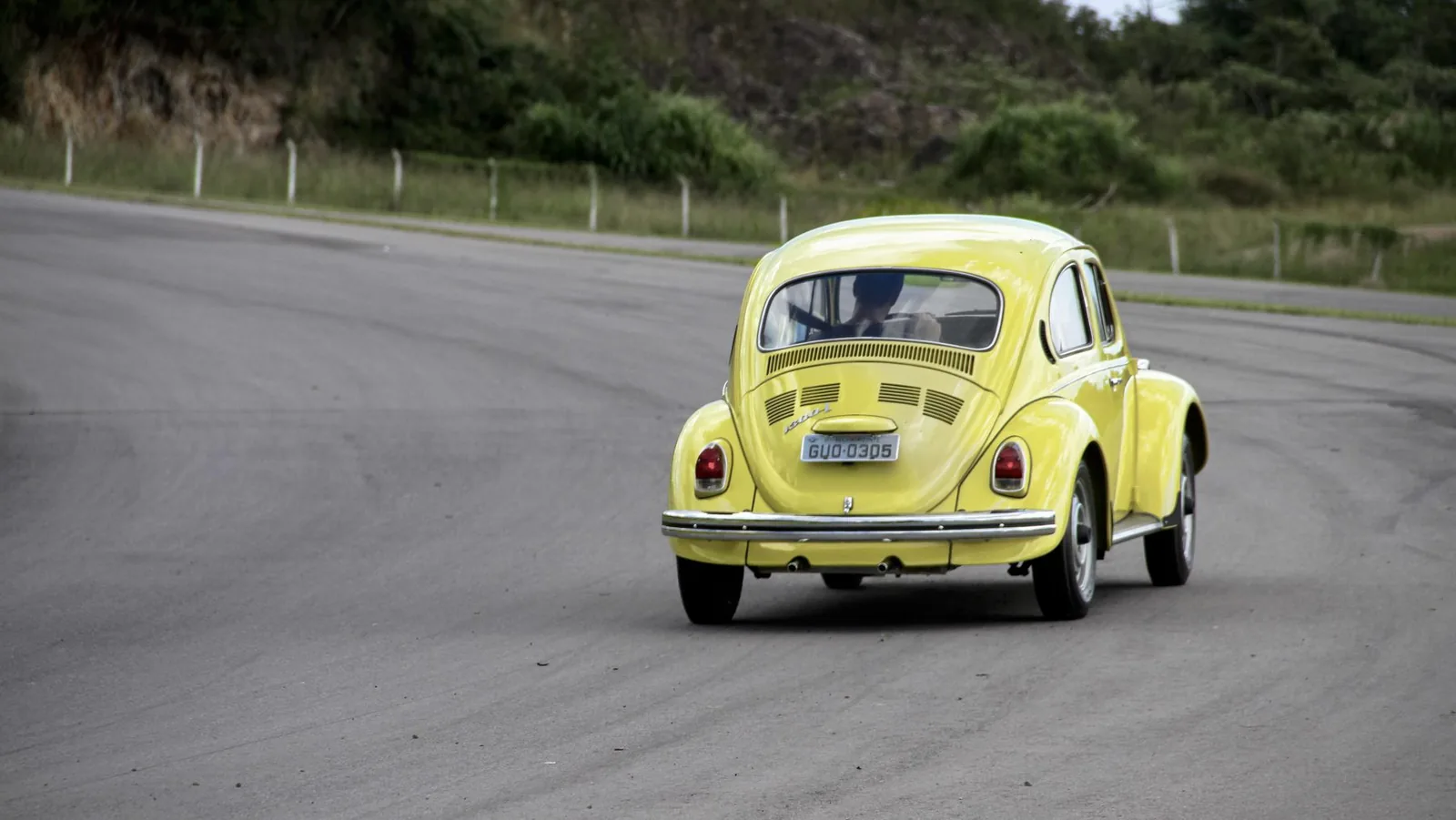 Fusca amarelo em movimento na pista