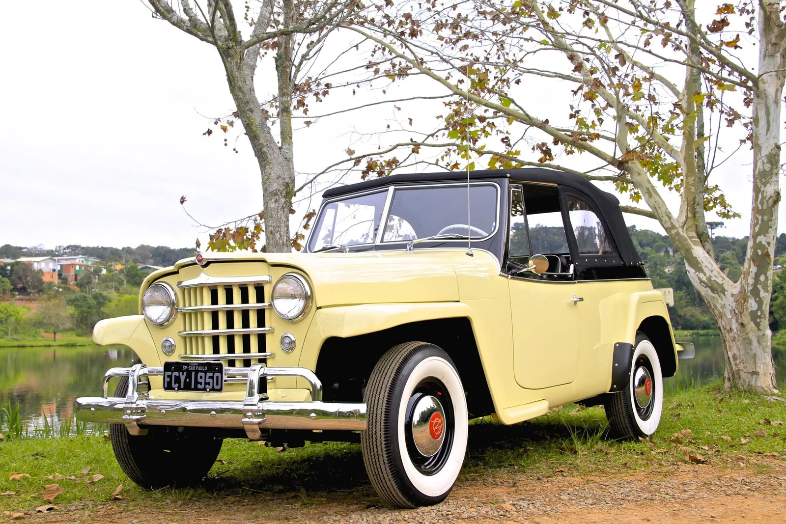Willys Jeepster 1950 amarelo à beira de um lago